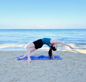 her healthy passport doing beach yoga at Secrets Aura Cozumel